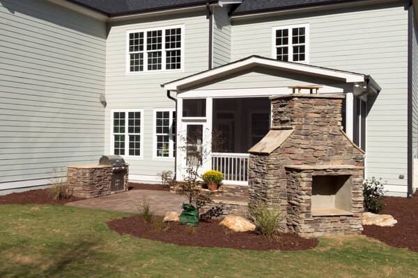 Outdoor stone fireplace and grill on concrete patio
